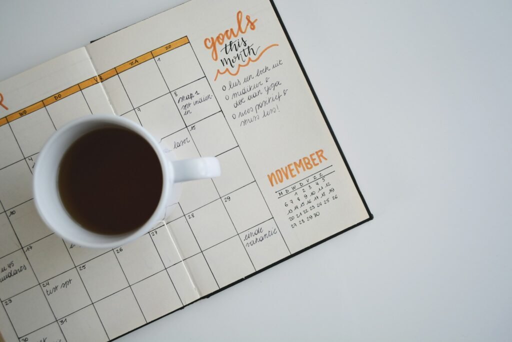 Cahier avec un calendrier de la semaine avec une tasse de thé posée dessus.