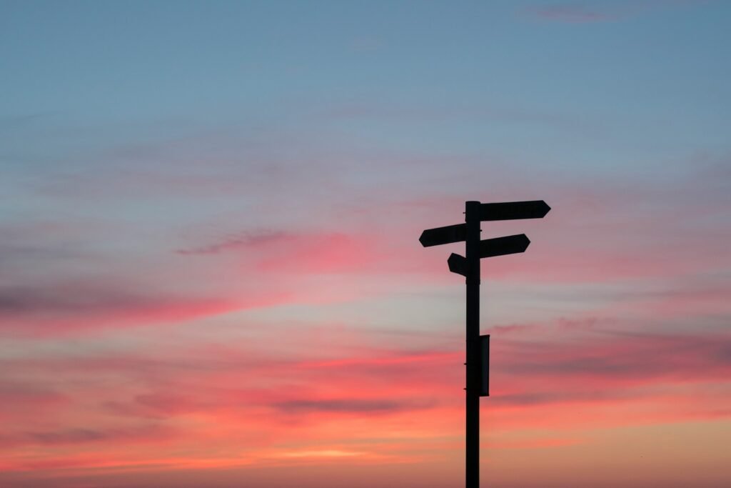 Ciel dégradé de couleur avec un panneau de plusieurs directions sous l'ombre.