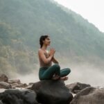 Femme faisant du yoga sur un rocher