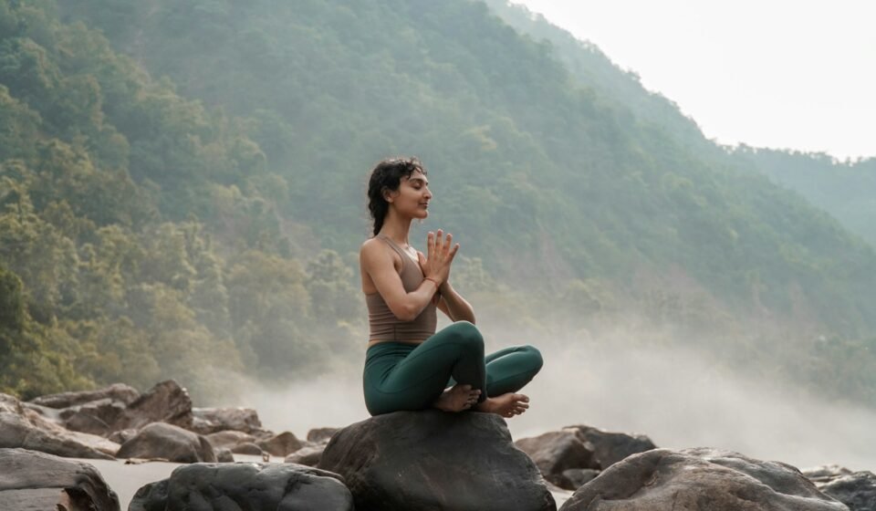 Femme faisant du yoga sur un rocher