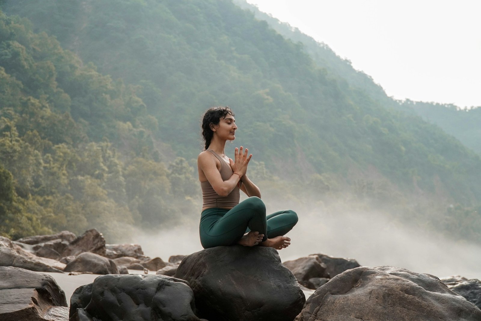 Femme faisant du yoga sur un rocher
